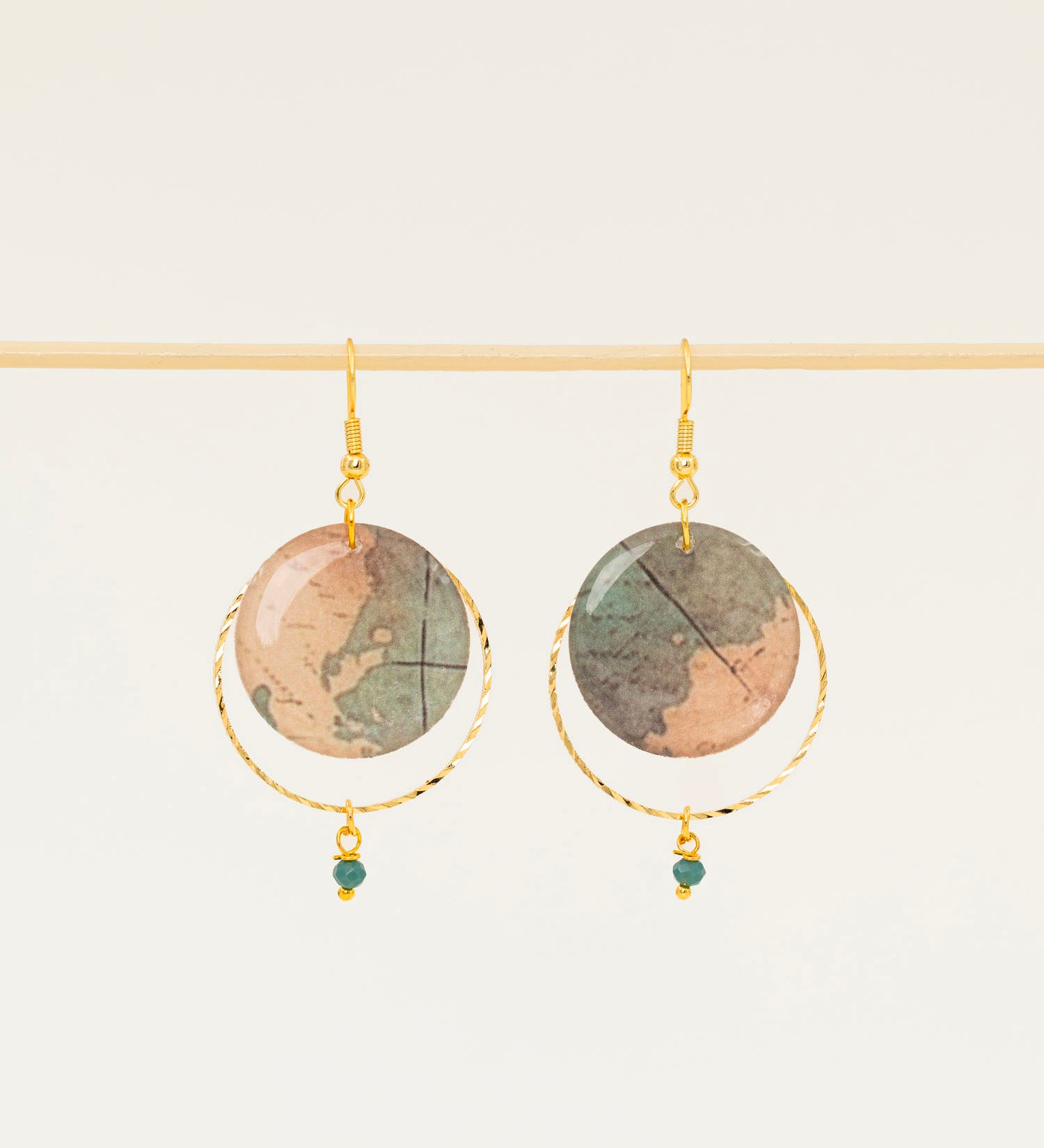Boucles d'oreilles Sacramento, disque carte ancienne, anneau laiton doré torsadé et perle turquoise africaine, fond crème