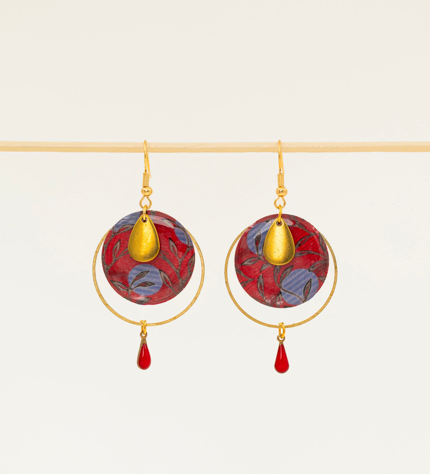 Boucles d'oreilles Asmara, disque wax rouge et bleu, anneau laiton doré et goutte émail rouge, fond crème