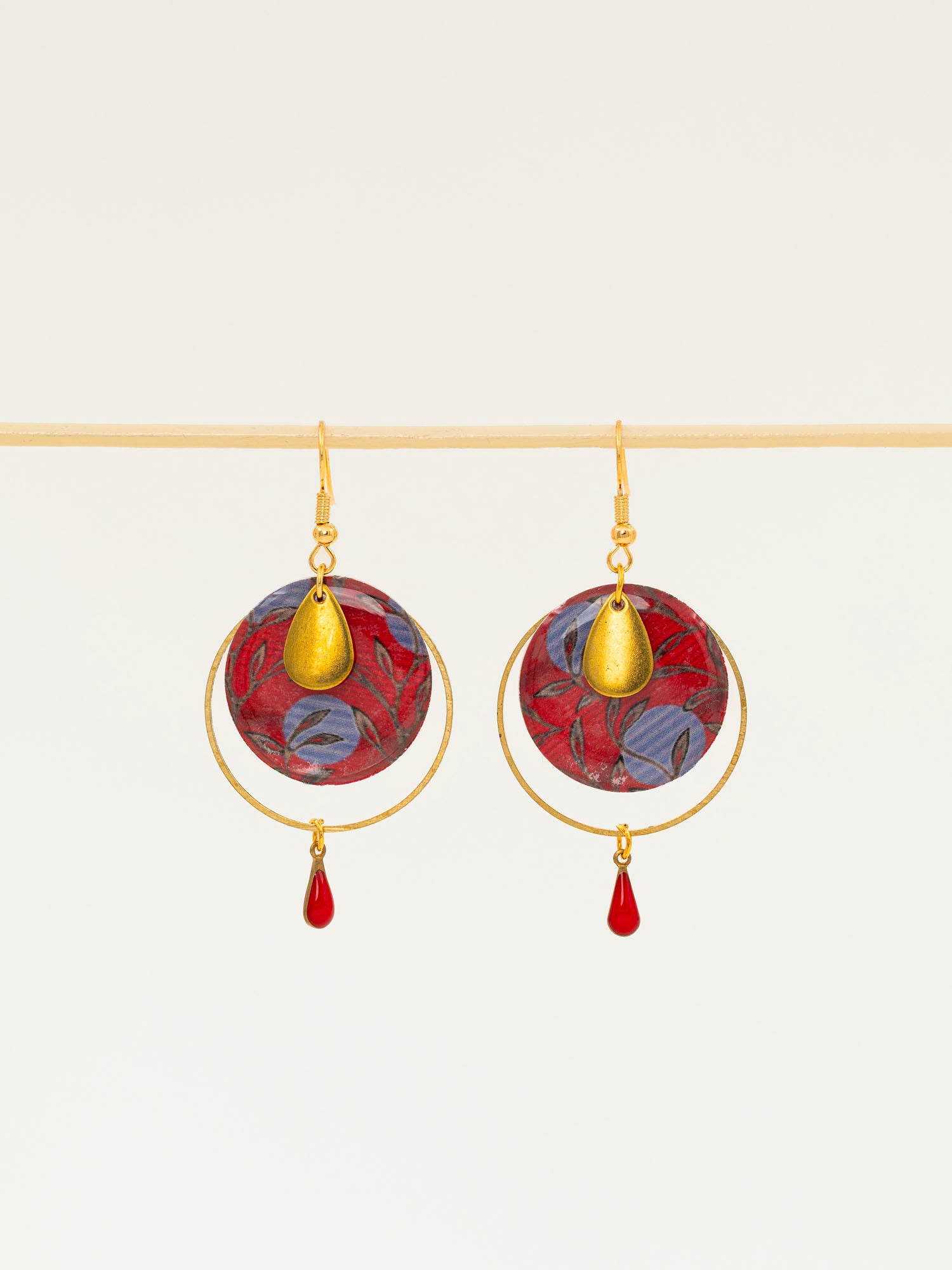 Boucles d'oreilles Asmara, disque wax rouge et bleu, anneau laiton doré et goutte émail rouge, fond crème