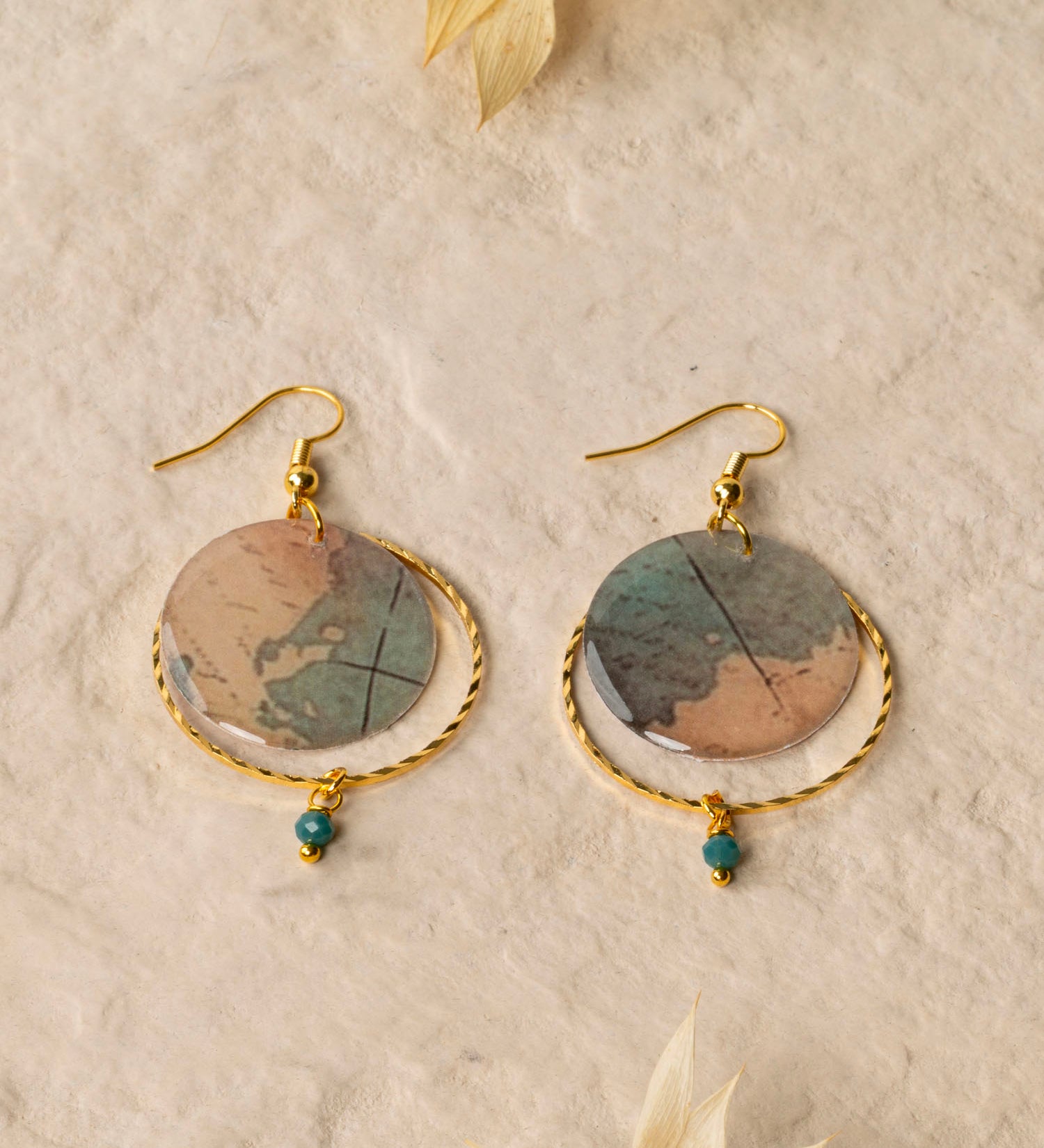 Boucles d'oreilles Sacramento, disque carte ancienne, anneau laiton doré torsadé et perle turquoise africaine, fond crème