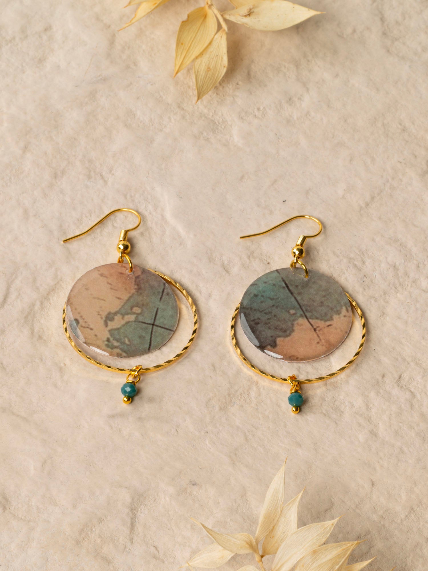 Boucles d'oreilles Sacramento, disque carte ancienne, anneau laiton doré torsadé et perle turquoise africaine, fond crème