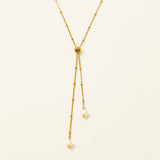 Collier Amalfi, chaîne satellite dorée forme Y et perles pierre de lune, fond crème