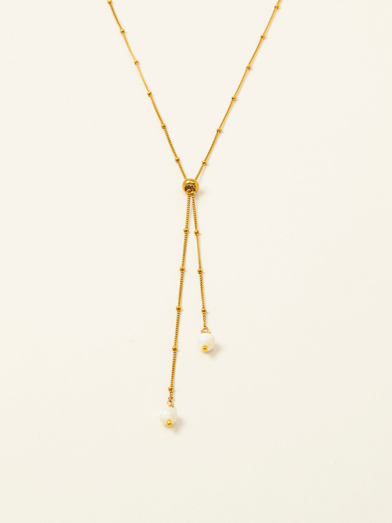 Collier Amalfi, chaîne satellite dorée forme Y et perles pierre de lune, fond crème