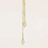 Collier Amalfi, chaîne satellite dorée forme Y et perles pierre de lune, fond crème