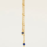 Collier Essaouira, chaîne satellite dorée forme Y et perles lapis-lazuli, fond crème