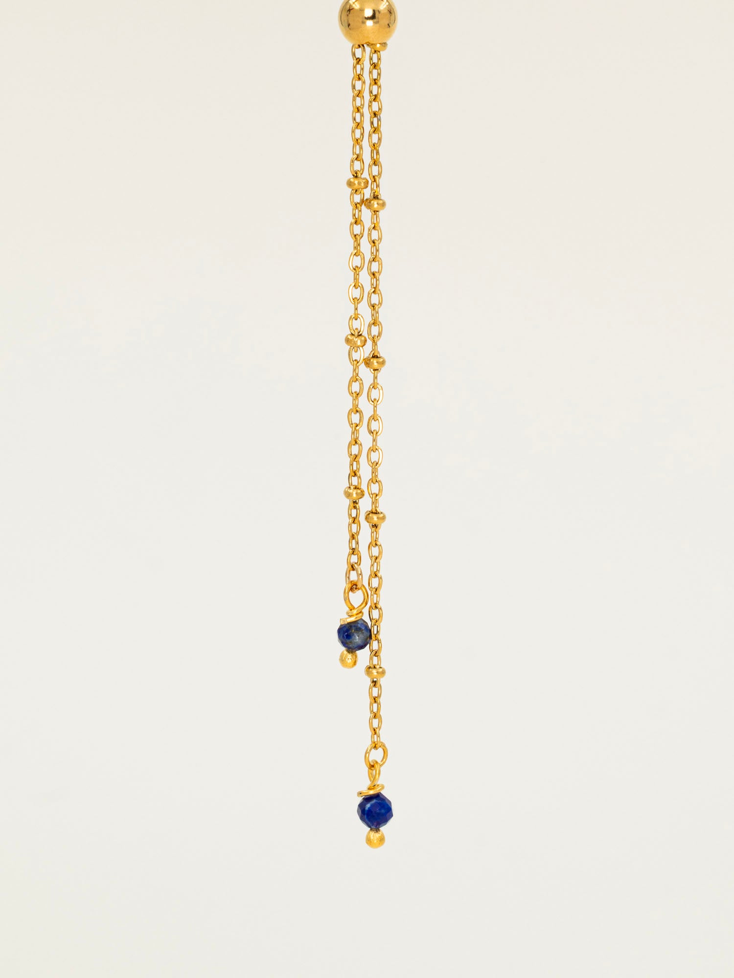 Collier Essaouira, chaîne satellite dorée forme Y et perles lapis-lazuli, fond crème