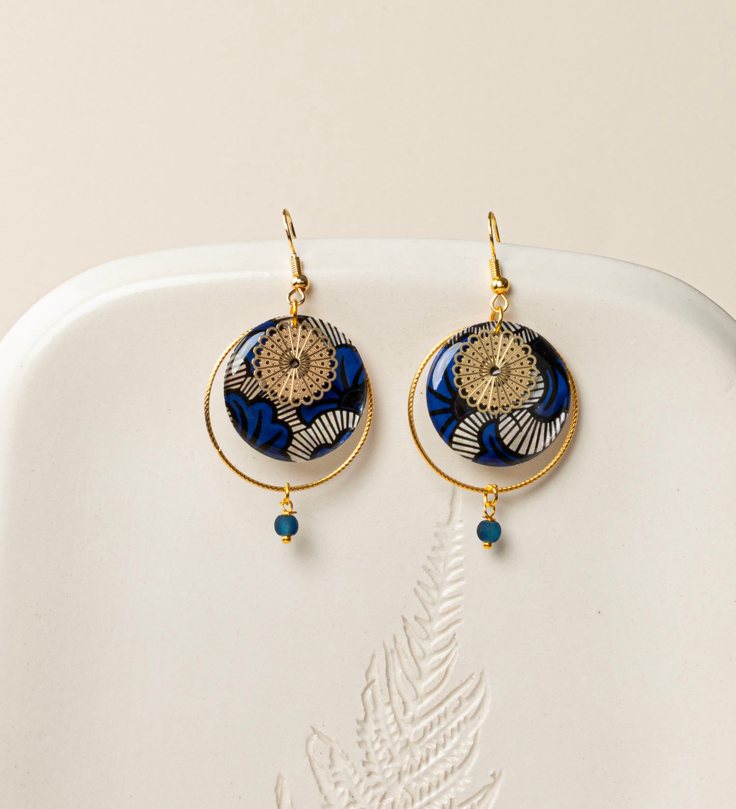Boucles d'oreilles artisanales Lusaka - wax résiné bleu graphique et rosace dorée ajourée, fait main en France