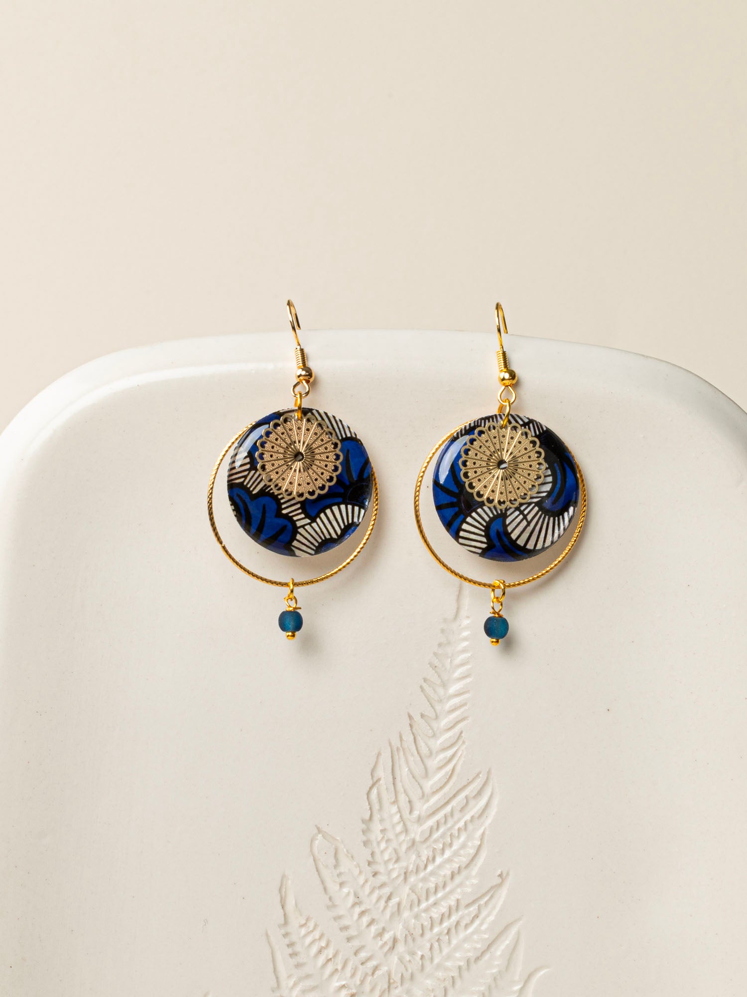 Boucles d'oreilles artisanales Lusaka - wax résiné bleu graphique et rosace dorée ajourée, fait main en France