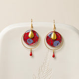 Boucles d'oreilles Asmara, disque wax rouge et bleu, anneau laiton doré et goutte émail rouge, fond crème