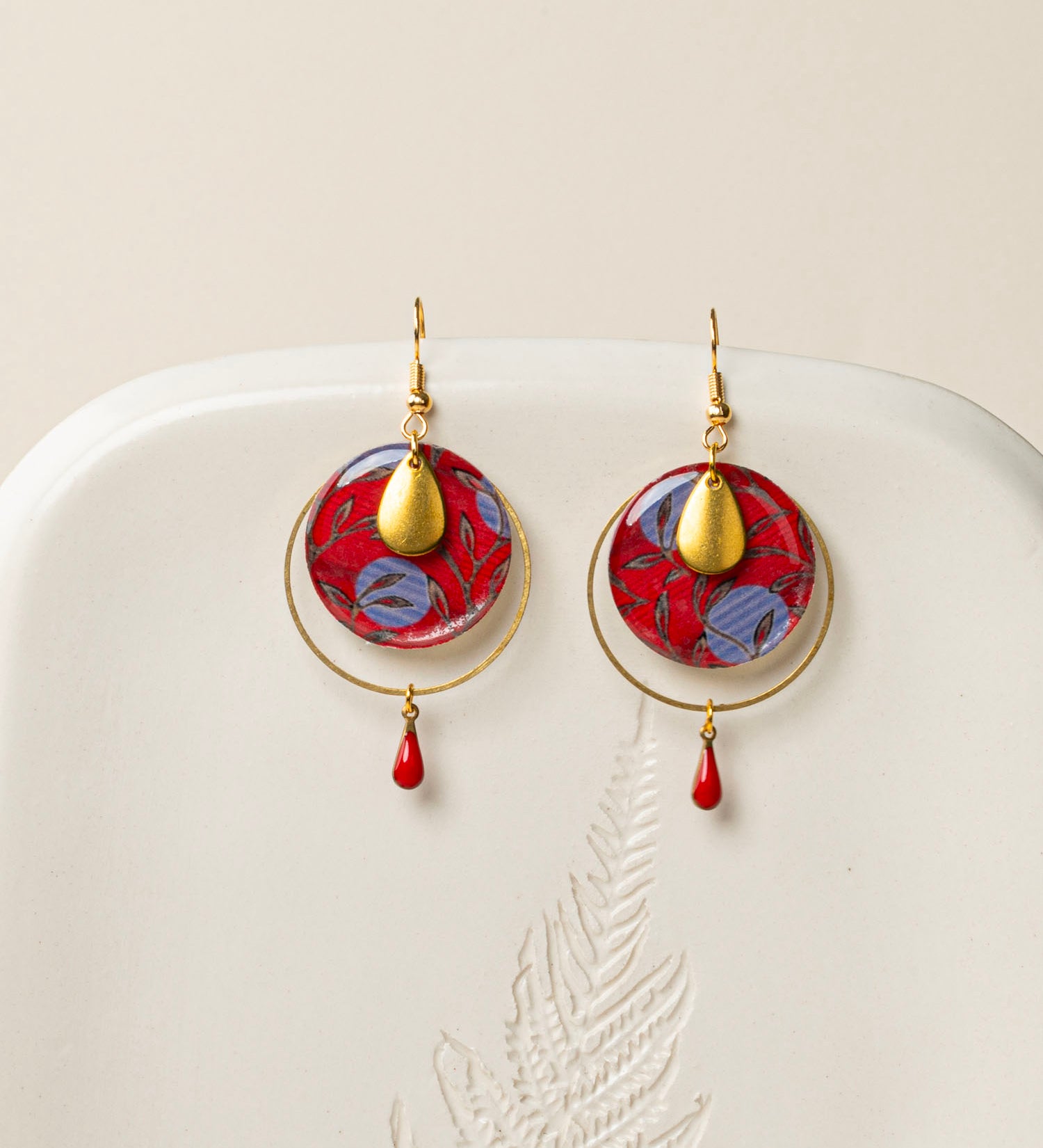 Boucles d'oreilles Asmara, disque wax rouge et bleu, anneau laiton doré et goutte émail rouge, fond crème