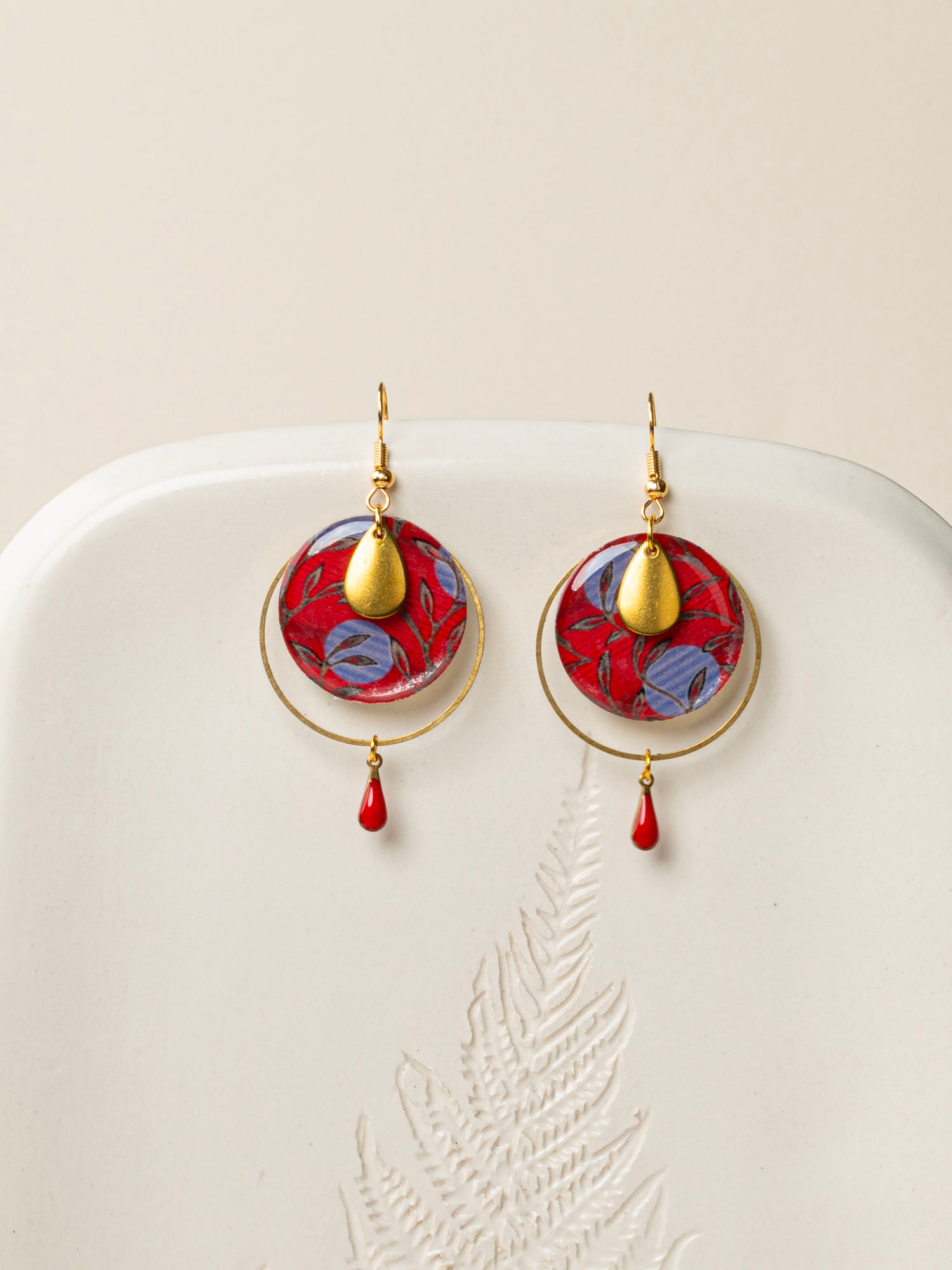 Boucles d'oreilles Asmara, disque wax rouge et bleu, anneau laiton doré et goutte émail rouge, fond crème