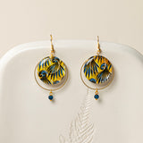 Boucles d'oreilles Conakry, disque wax jaune et bleu pétrole, anneau laiton brut et perle verre mat, fond crème
