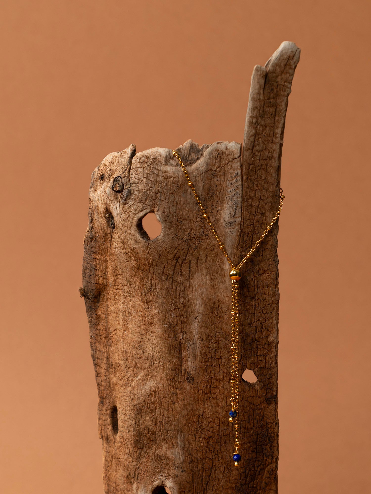 Collier Essaouira, chaîne satellite dorée forme Y et perles lapis-lazuli, fond crème