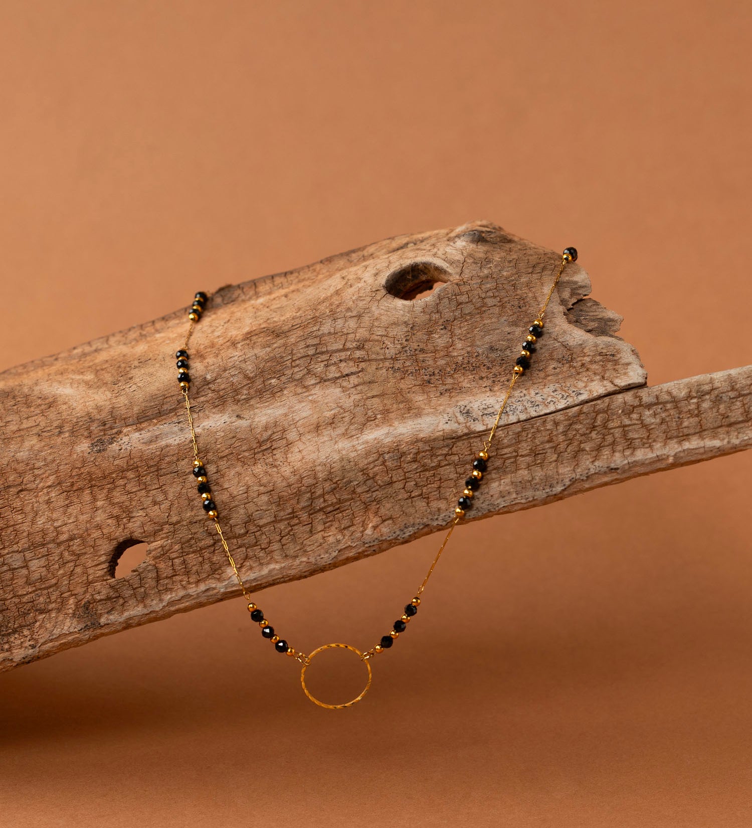 Collier artisanal Cassis - perles d'onyx et anneau doré ciselé, plaqué or 24K, fait main en France