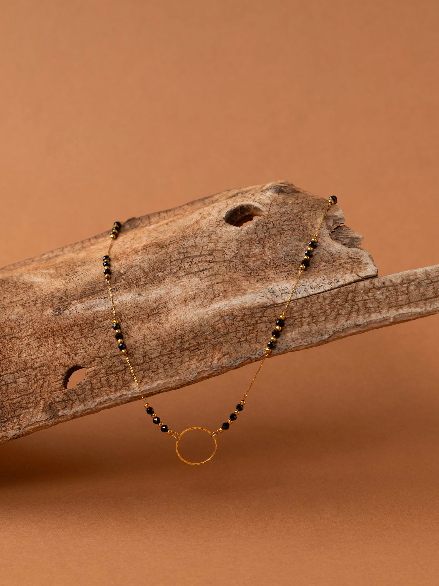 Collier artisanal Cassis - perles d'onyx et anneau doré ciselé, plaqué or 24K, fait main en France
